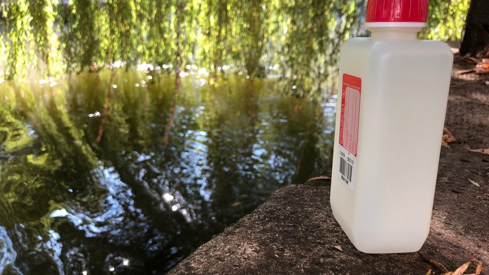 Eine Probenahmeflasche an einem Fluss