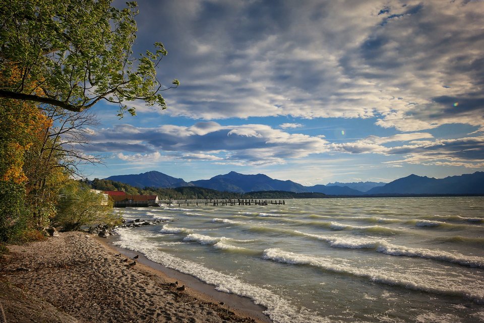 Chiemsee mit Wellen und Alpen im Hintergrund.